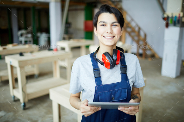 Smiling female carpenter with tablet - Stock Photo - Images
