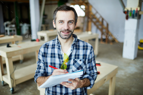 Handsome carpenter developing design of new detail - Stock Photo - Images