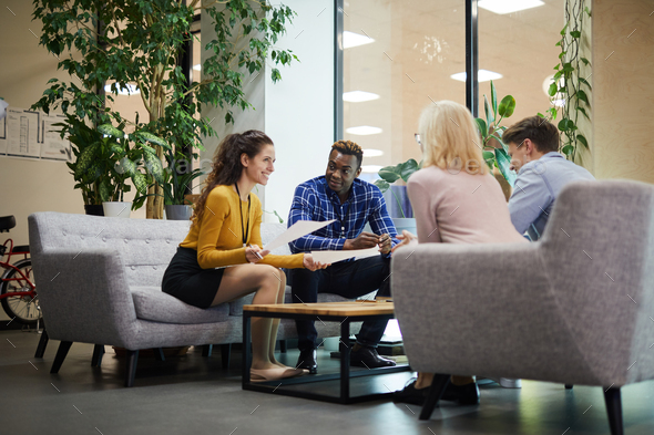 Creative team discussing sales statistics in office - Stock Photo - Images