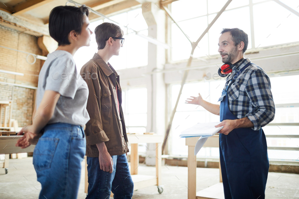 Builder presenting house project to customers - Stock Photo - Images