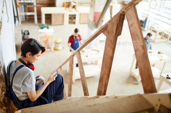 Lady carpenter having short break in workshop - Stock Photo - Images