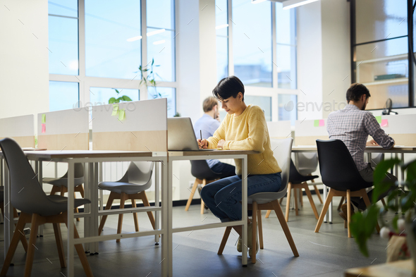 Student girl working on project in coworking space - Stock Photo - Images