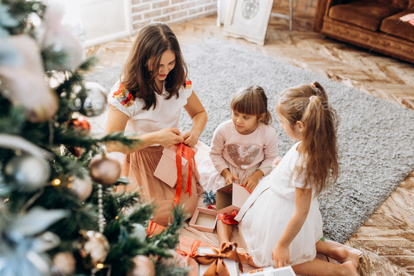 Happy young mother and her two charming daughters in nice dresse - Stock Photo - Images