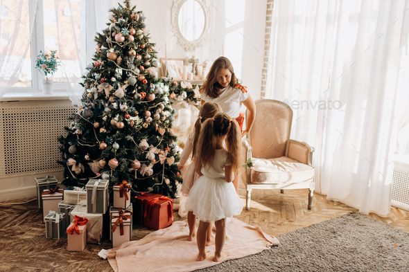 Young mother and her two charming daughter in nice dresses stand - Stock Photo - Images