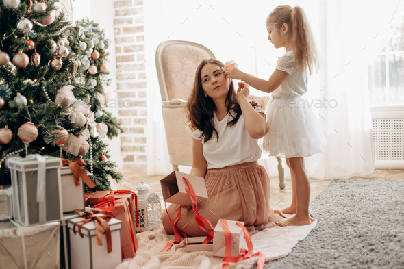Happy young mother and her little daughter in nice dress sit ne - Stock Photo - Images