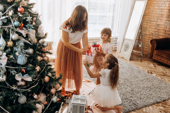 Happy young mother and her two charming daughter in nice dresses - Stock Photo - Images