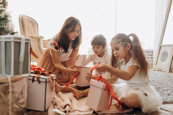 Happy young mother and her two charming daughters in nice dresse - Stock Photo - Images