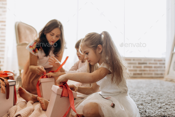 Happy young mother and her two charming daughters in nice dresse - Stock Photo - Images