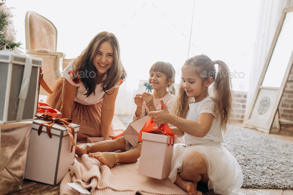 Happy young mother and her two charming daughters in nice dresse - Stock Photo - Images