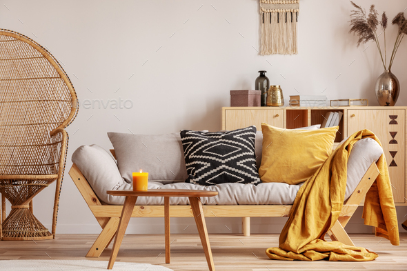 Stunning wicker peacock chair next to modern scandinavian settee with pillows - Stock Photo - Images