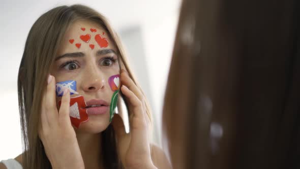 Close-up Portrait of Young Attractive Woman with Painted Social Media Icons on Her Face Looking alt
