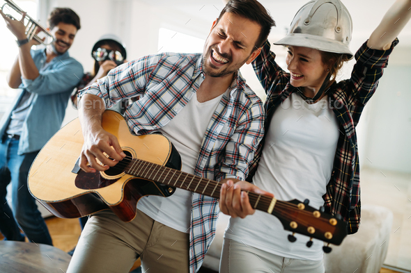 Cheerful friends having party together and playing instruments - Stock Photo - Images