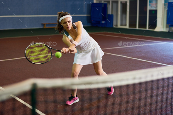 Woman Playing Tennis in Court - Stock Photo - Images