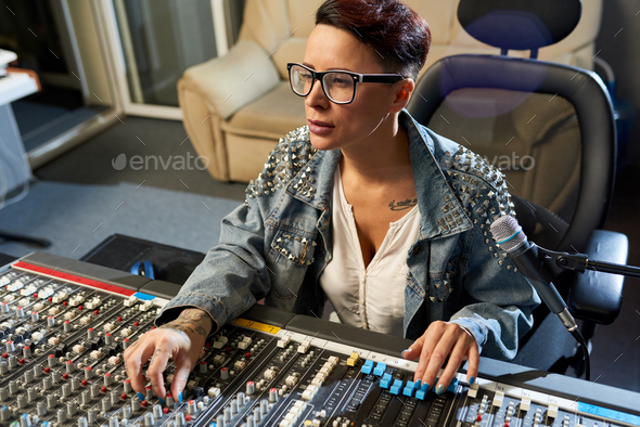 Pensive sound director using audio mixer in studio - Stock Photo - Images