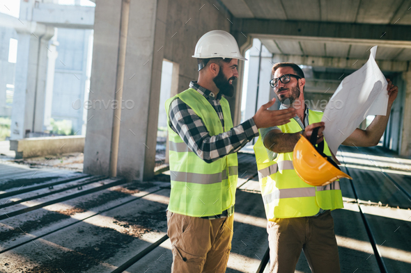 Portrait of construction engineers working on building site - Stock Photo - Images