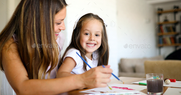 Mother looking how her child daughter drawing - Stock Photo - Images