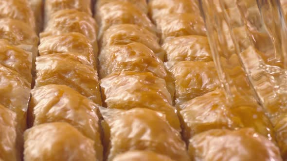 Sherbet pours down onto baklavas in slow motion