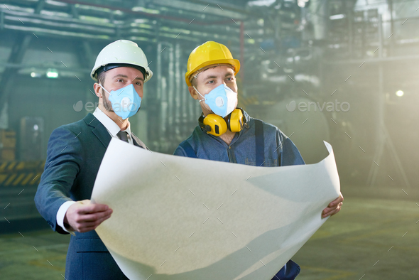 Engineers Holding Blueprints at Factory - Stock Photo - Images