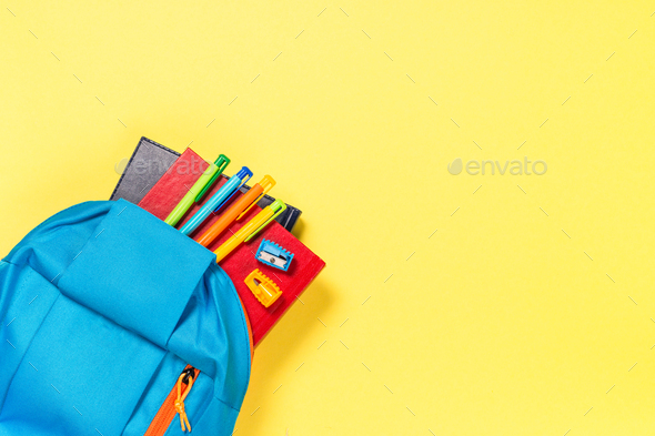 School backpack with stationery on yellow background - Stock Photo - Images