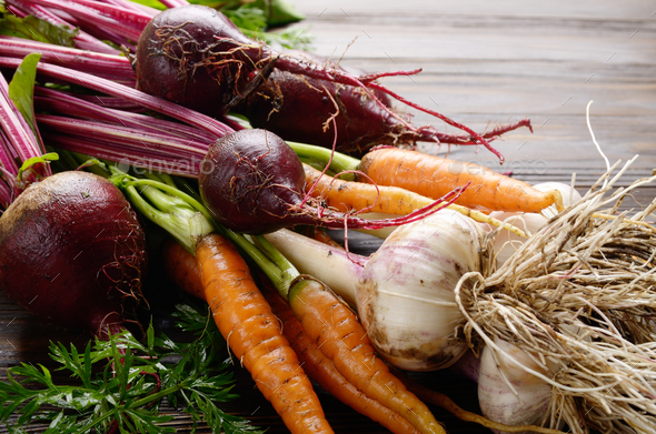 Fresh organic beetroots green garlic and carrots on kitchen wood - Stock Photo - Images