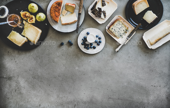 Variety of snacks, jam and cheeses over grey background - Stock Photo - Images