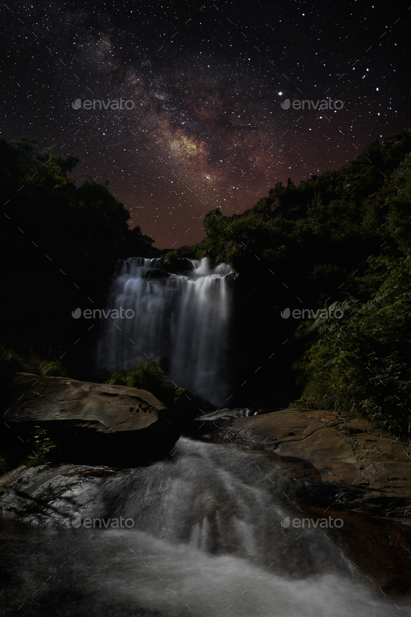 The Milky Way over a Waterfall illuminated by the Moonlight - Stock Photo - Images