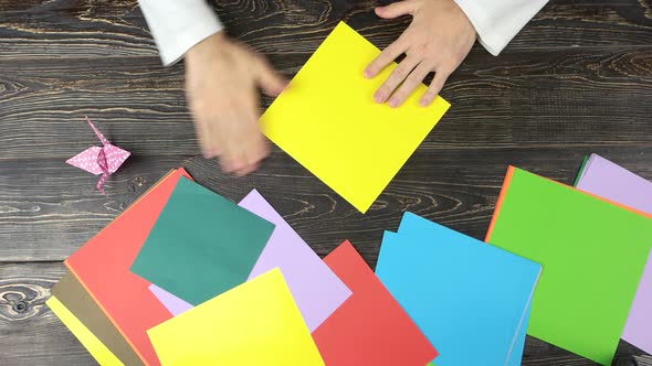 Man Folding Paper As Triangle alt