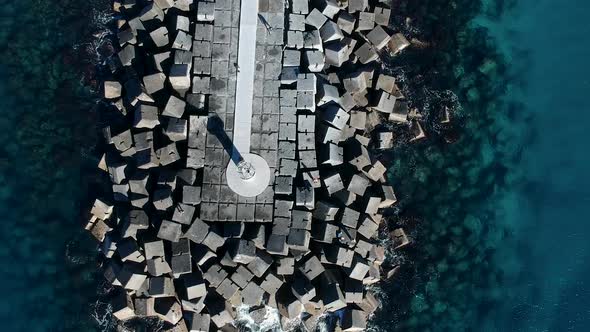 Aerial view of a rock break-wall with clear water on both sides alt