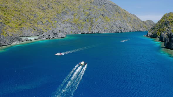 Drone Follow Island Hopping Boats in Strait Between Matinloc and Tapiutan Island in El Nido Palawan alt