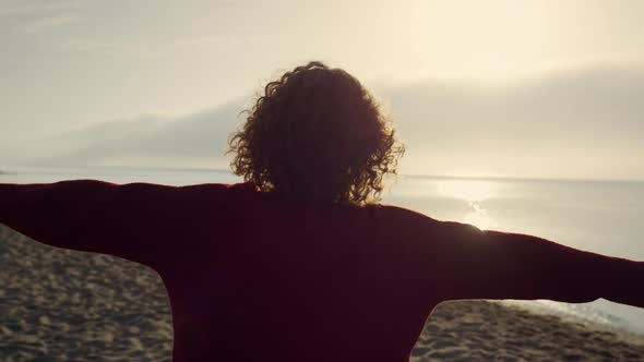 Casual Woman Raising Hands on Beach alt
