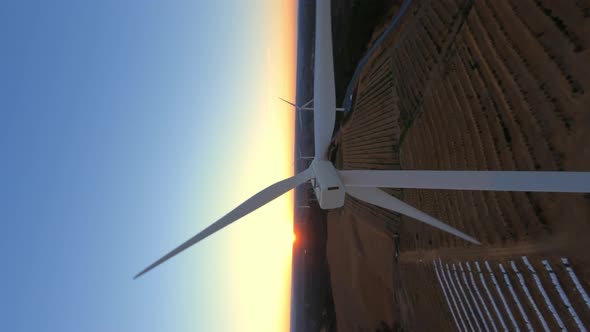 Vertical Dynamic Fpv Shot of White Operative Wind Turbine While Beautiful Sunset