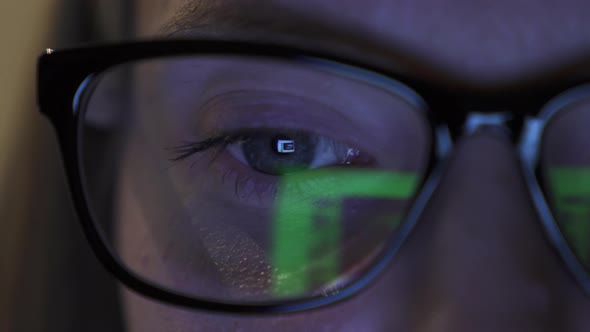 Detailed View on Girl's Eye in Glasses, Reflection of Screen of Laptop in Eye alt