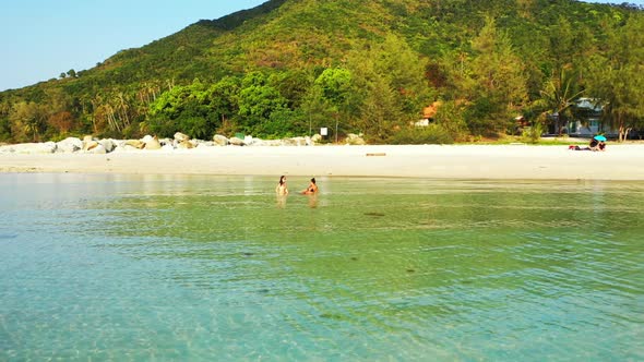 Girls tanning on tropical tourist beach journey by turquoise water with white sandy background of Th alt