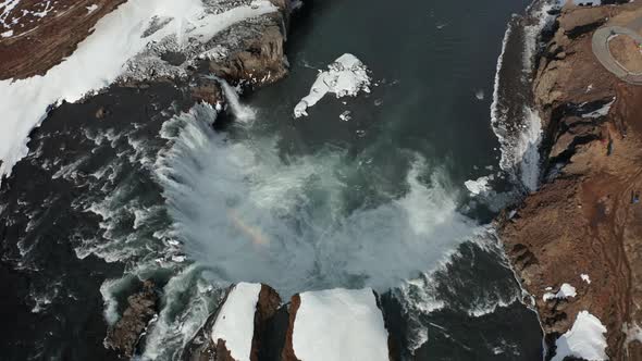 Aerial View of Godafoss Waterfall with Snowy Shore and Ice. Iceland. Winter 2019