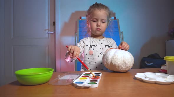 Little Girl Crafting Some Fake Pumpking for Halloween