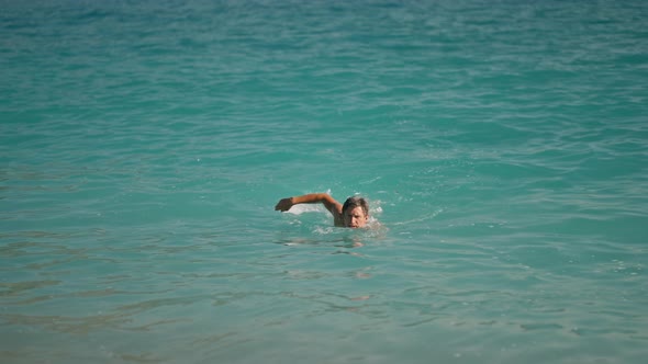 Sportsman Athletic Man Swims in Turquoise Water of Mediterranean Sea in Oludeniz Beach in Aegean Sea alt