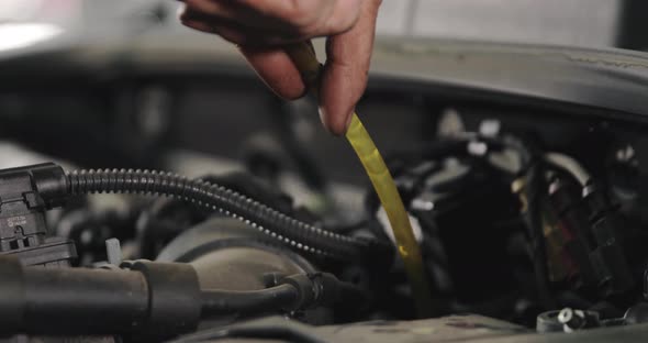 Mechanic Draining Old Brake Fluid From A System During The Service. Close Up alt