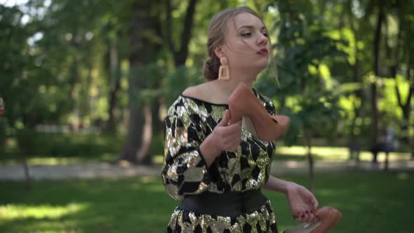 Side View Irritated Annoyed Young Beautiful Woman with Broken Heart Strolling in Summer Park Holding alt