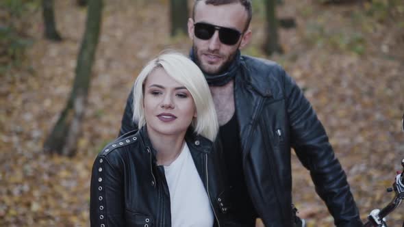 Couple Standing in Park Man Undressing Sunglasses and Looking on Girl alt
