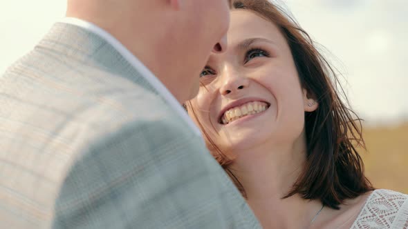 Happy Groom and Brunette Bride Smiling to Each Other Hugging at Summer Outdoor alt