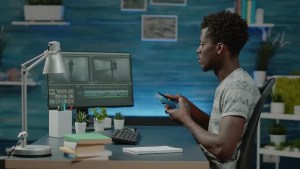 Videographer with Headphones Editing Montage for Music Video alt