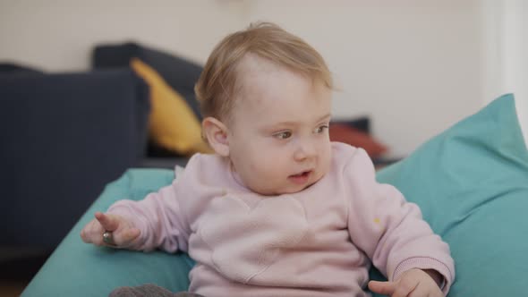 Cute baby girl playing at home and smiling to the camera alt