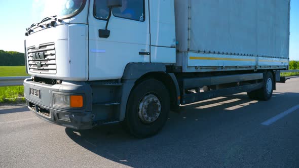 Camera Follows to Truck with Cargo Trailer Driving on Highway and Transporting Goods at Summer Day