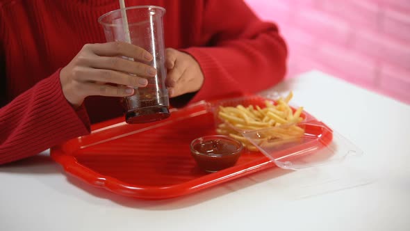 Female Customer Drinking Carbonated Water From Plastic Glass, Unhealthy Lunch alt