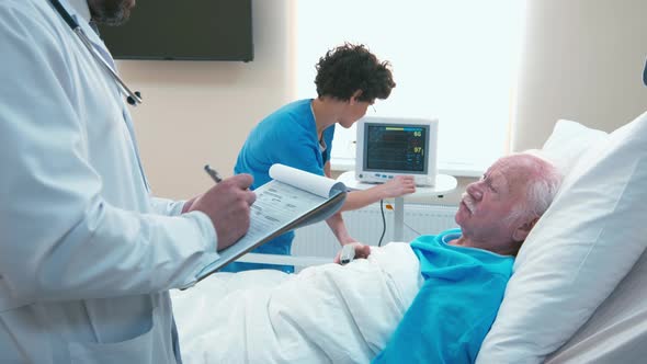 Doctor questioning old patient in hospital room