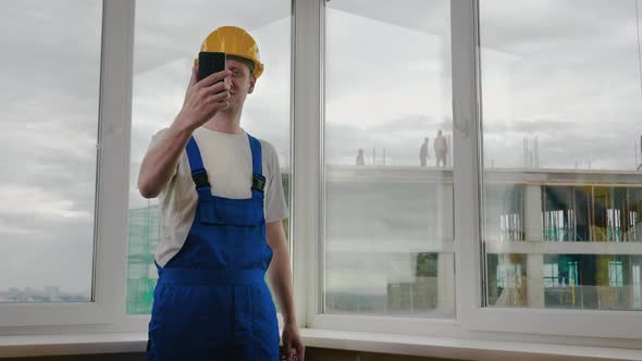 Builders Making a Selfie with His Phone Construction Site. alt