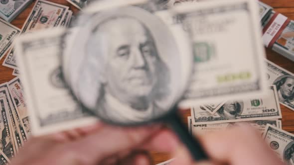 One Hundred Dollars Look Under Magnifying Glass Above Money Table alt