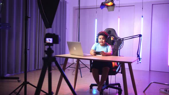 Asian Little Boy Holding Mobile Phone With Mock Up Green Screen And Talking While Live Stream alt