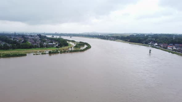 Flood landscape of river Meuse. Smeermaas, Belgium. Aerial flying backwards alt