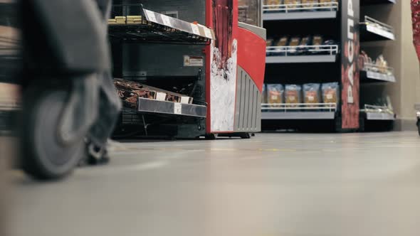 Feet of a Woman with a Cart Gets in Line at a Grocery Store